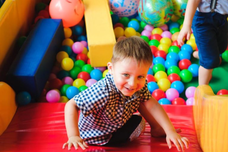 Kinderen spelen in indoorspeeltuin op camping met glijbanen en klimrekken voor zorgeloze gezinsvakantie